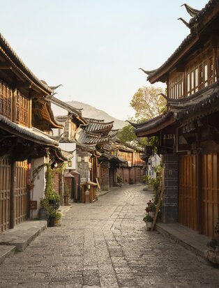 Stone-paved street lined with traditional wooden buildings in Lijiang Old Town, where Amandayan is located.