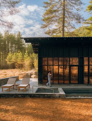 Spa house at Amankora's Paro Lodge with wooden decking and forest views at dusk.