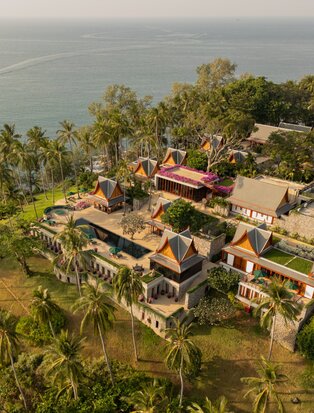 Aerial view of an eight-bedroom ocean villa at Amanpuri, Thailand, surrounded by tropical gardens and coastline.
