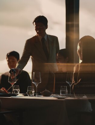 Aman Tokyo dining venue with guests seated at table during golden hour.
