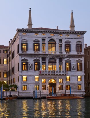 Palazzo exterior at Aman Venice illuminated at dusk, overlooking the canal.