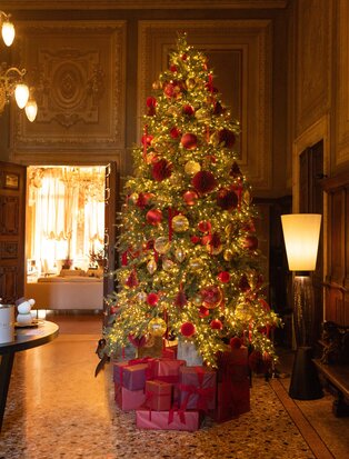 Decorated Christmas tree with red and gold ornaments in the Noble Floor at Aman Venice.