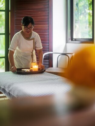 Therapist preparing a wellness treatment at Aman Villas Nusa Dua spa.
