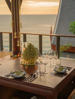 Private dining pavilion set for Royal Thai dinner at Amanpuri, Thailand, with table settings and sea views.