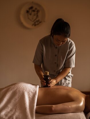 Therapist performing moxibustion and cupping treatment on guest at Amandayan wellness spa.