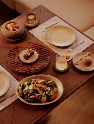 Amanvari beach club dining table with place settings and shared dishes.