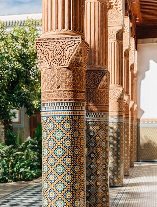Carved stone column with geometric tilework at Amanjena, Marrakech.