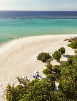 Amanpulo villa with private beach access, turquoise waters and white sand.