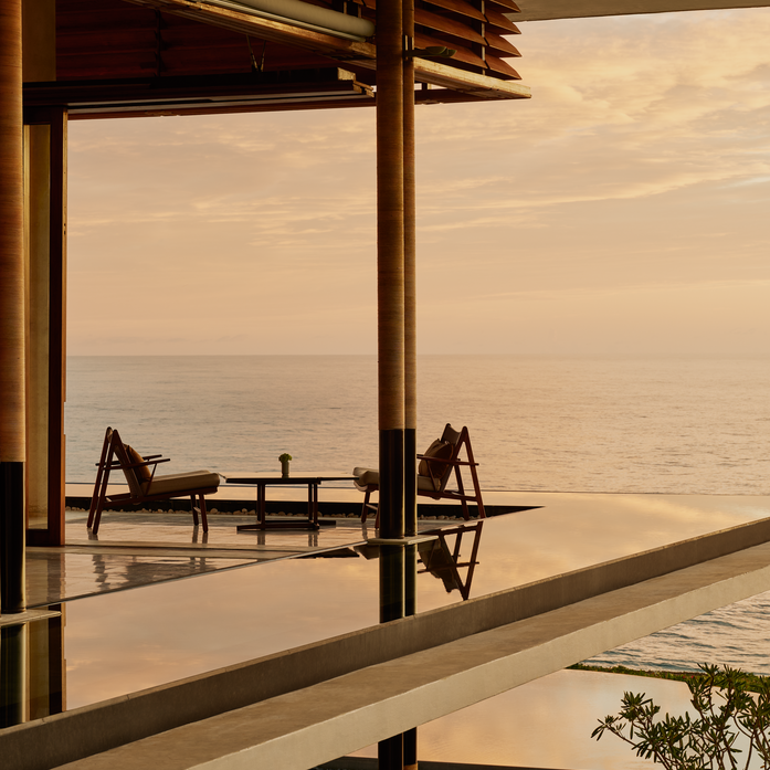 Resort lounge bar at Amanera with open doors framing ocean views at sunset, Dominican Republic.