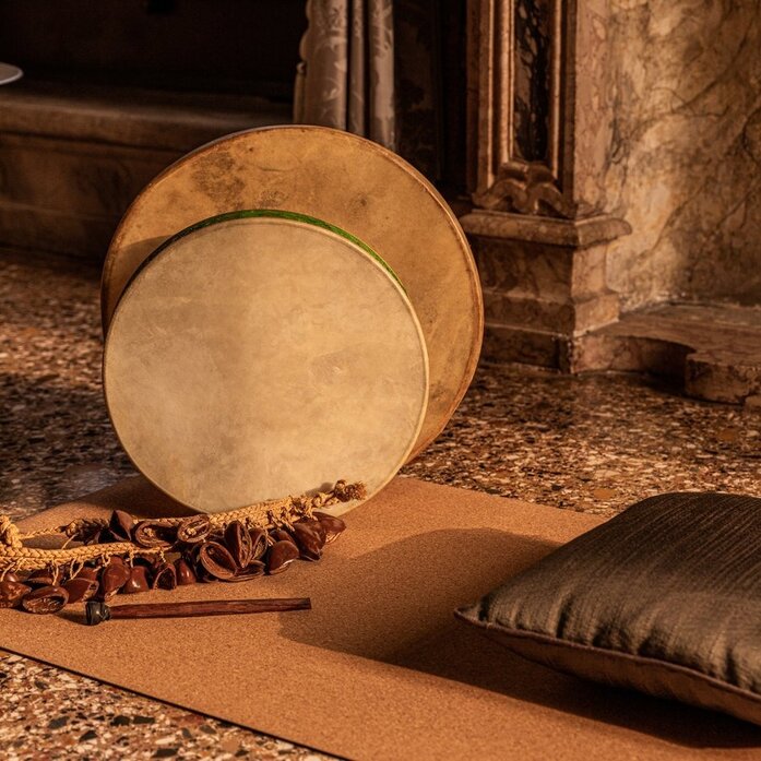 安缦威尼斯水疗中心的音疗室内，一面大鼓放在垫子上，旁边放着黑色靠垫。