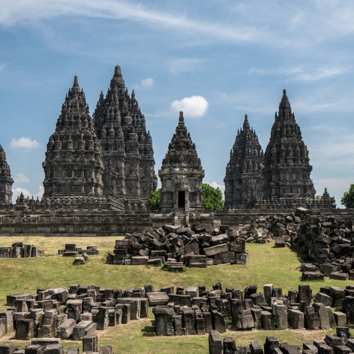 Candi Prambanan dengan menara-menara batu yang megah dikelilingi reruntuhan, dilihat dari Amanjiwo resort.