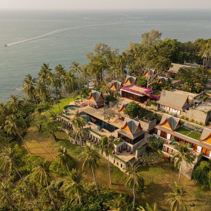 Aerial view of an eight-bedroom ocean villa at Amanpuri, Thailand, surrounded by tropical palms and overlooking the Andaman Sea.