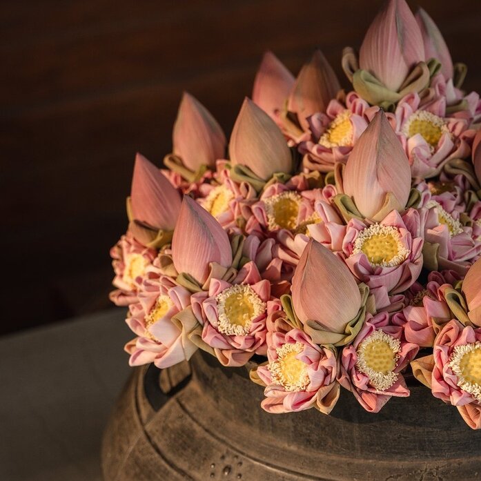 Floral arrangement with pink and yellow orchids in a woven basket at Amansara, Cambodia.