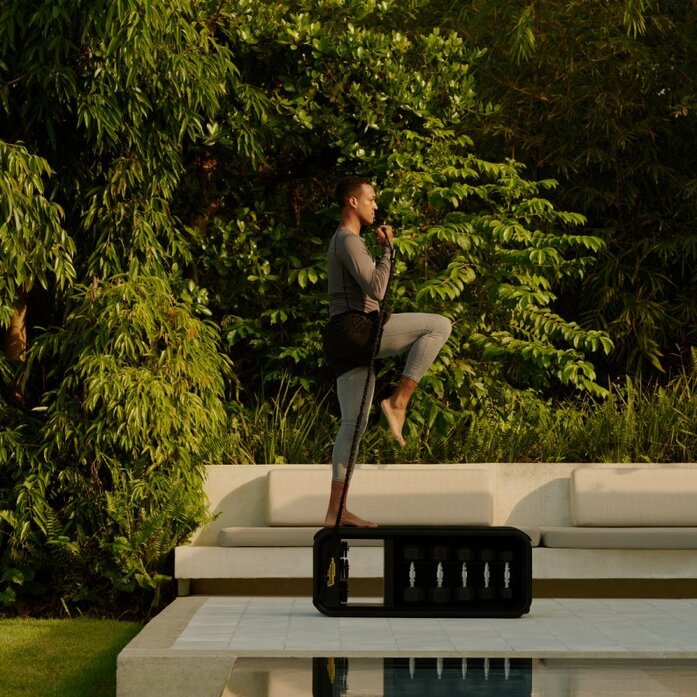 Casita gym at Amanera resort in the Dominican Republic, woman stretching outdoors among lush greenery.