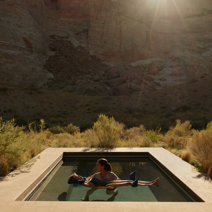 Water Shiatsu pavilion at Amangiri with therapist and guest in heated pool beneath desert cliffs.