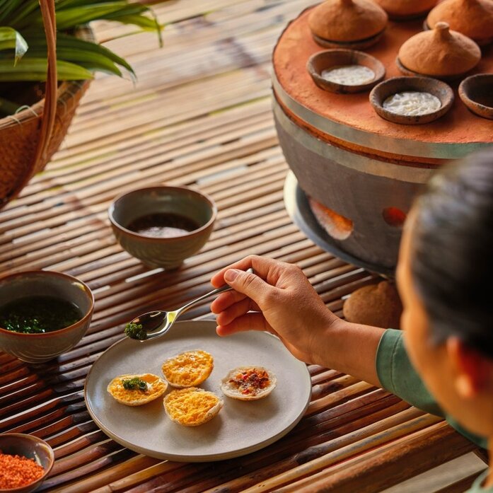 Afternoon tea service at Amanoi, with pastries and tea bowls arranged on a wooden table.