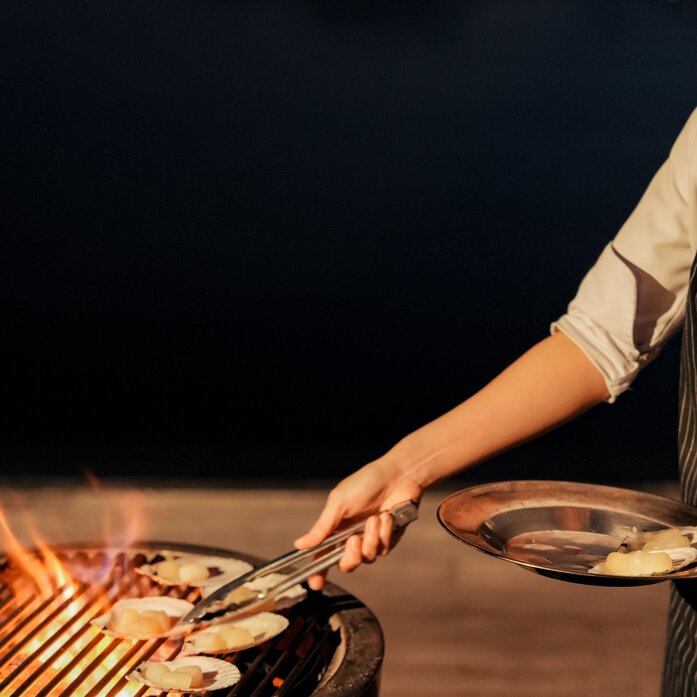 Hand plating grilled fish at Amanoi's dining venue in Vietnam.