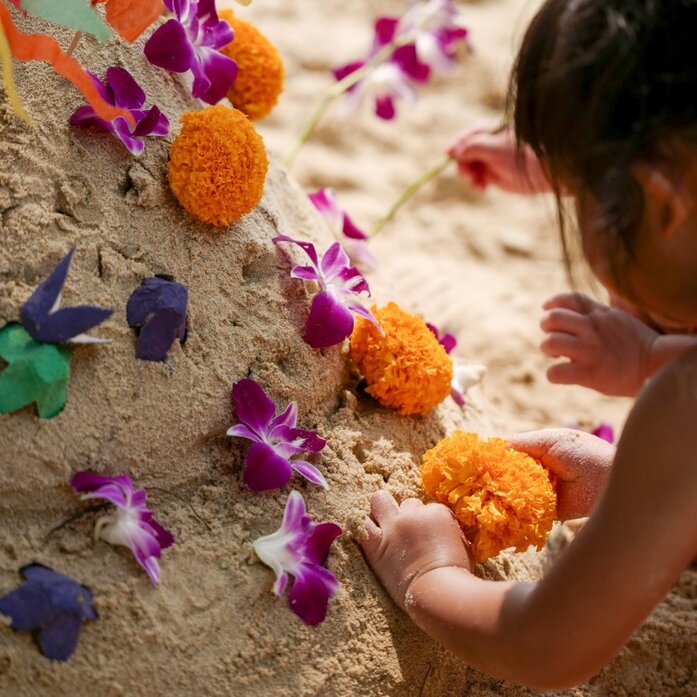 Child creating coloured sand patterns during Songkran celebration at Amanpuri, Thailand.