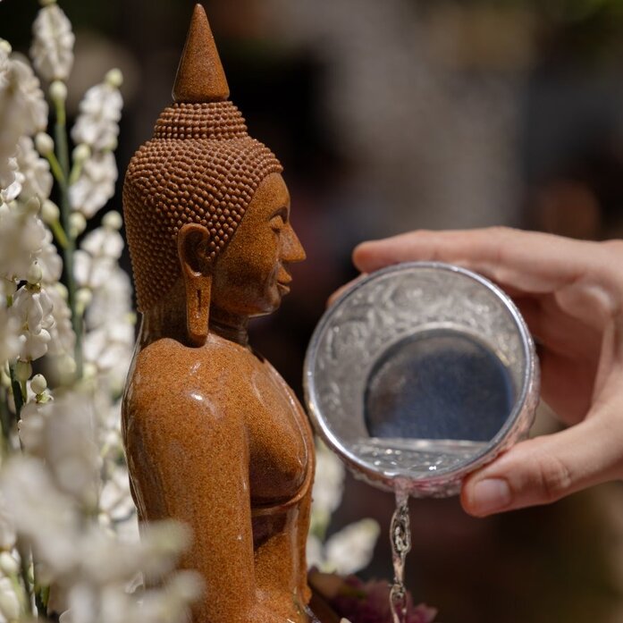 Buddhist statue being bathed with water from a bowl during Songkran celebrations at Amanpuri, Thailand.
