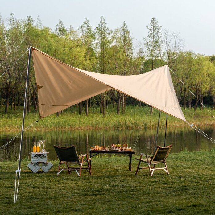 Afternoon tea setup by a tranquil lakeside at Amanyangyun, with fabric canopy and wooden furniture.