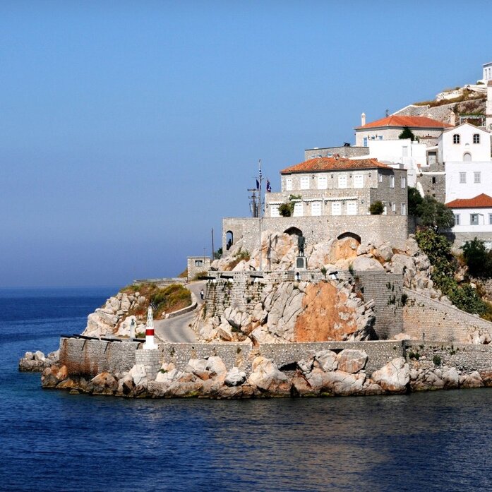 アマンゾイのリゾートから見るイドラ島の崖上に建つ白い建物と紺碧のエーゲ海。