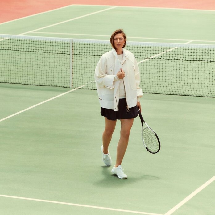 Tennis player holding racket on court at Amanzoe, Greece.
