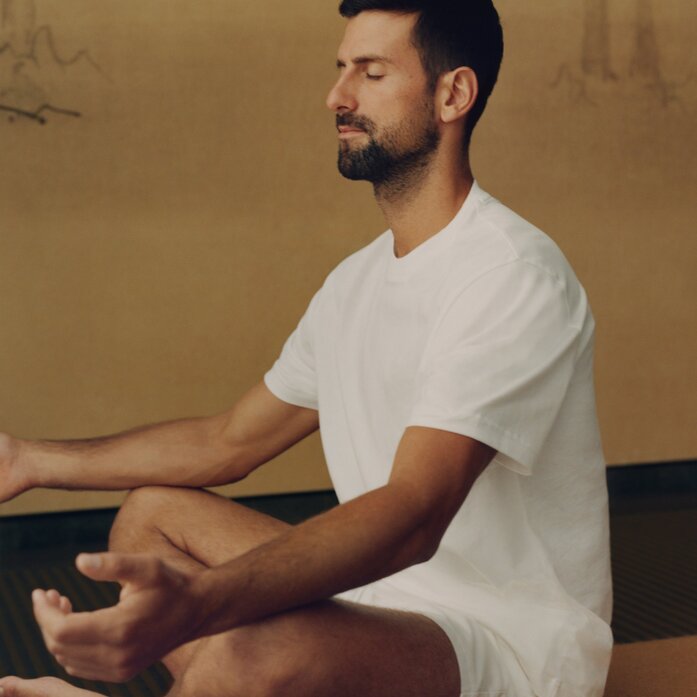 Novak Djokovic meditating in a serene studio space at Amanoi.