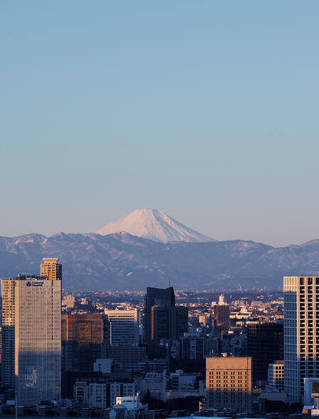 Aman Tokyo suite view of Mount Fuji rising above the city skyline at dawn.