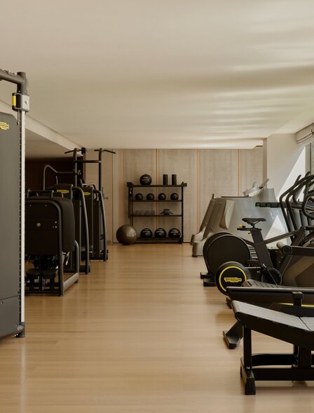 Fitness studio at Aman New York with exercise equipment and wooden flooring.