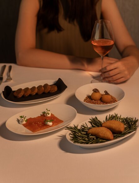 アマン ナイラート バンコクのダイニング会場で、バレンタインディナーコースの複数の料理が並べられている。