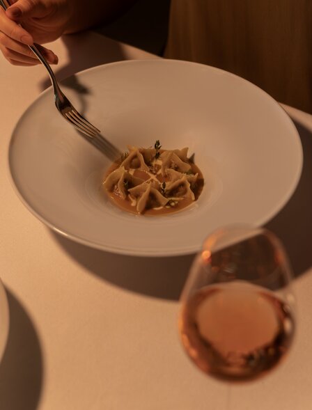 Plated dessert at Aman Nai Lert Bangkok with delicate pastry and rosé wine.
