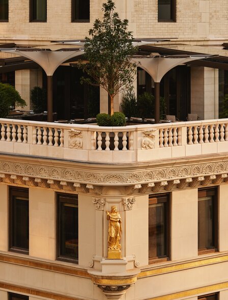 アマン ニューヨークのクラウンビルディング外観。ベージュ色の石造りの建物に、古典的なアーチ型の回廊と装飾的なバルスター欄干が特徴的です。