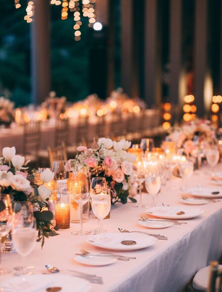 Wedding reception dinner setup at Amanoi's beach club restaurant with candlelit tables and place settings.