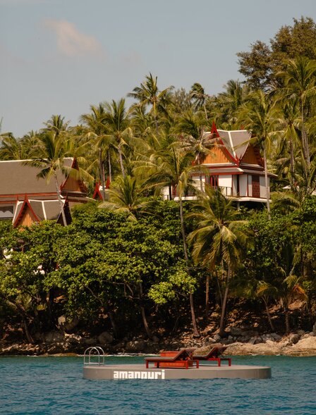 Amanpuri's ocean platform with traditional Thai architecture set amongst palm trees on the Andaman Sea shore.
