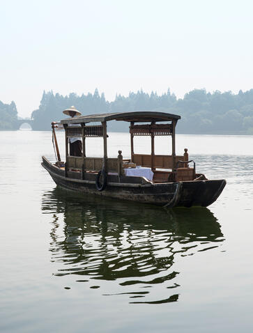 Traditional wooden boat on still water at Amanfayun, Chinese village.