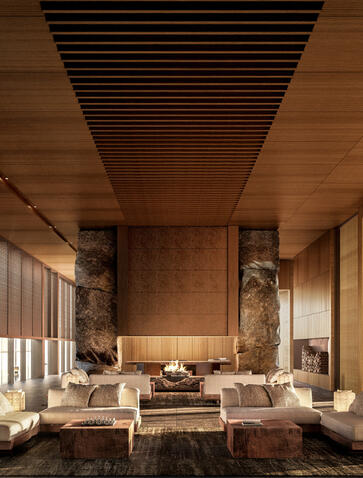 Entrance reception office at Aman Niseko, featuring warm timber ceiling and stone accents with contemporary seating.