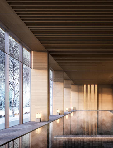 Spa swimming pool corridor at Aman Niseko with floor-to-ceiling windows overlooking snow-laden trees.