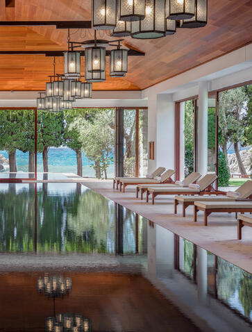 Wellness spa interior at Aman Sveti Stefan with reflective pool, wooden furnishings, and bay views.
