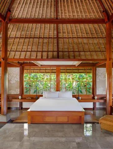 Village Suite bedroom at Amandari with alang-alang thatch roof and open pavilion design.