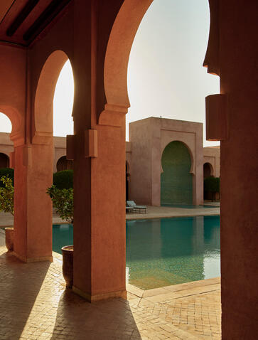 Amanjena resort's gallery featuring terracotta arches overlooking a tranquil plunge pool.
