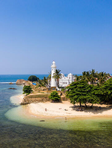 Aerial view of a temple on a sandy island surrounded by turquoise waters at Amanjiwo, Sri Lanka.
