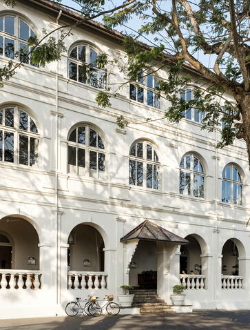 Whitewashed colonial façade of Amangalla with arched openings and ornamental balustrade.
