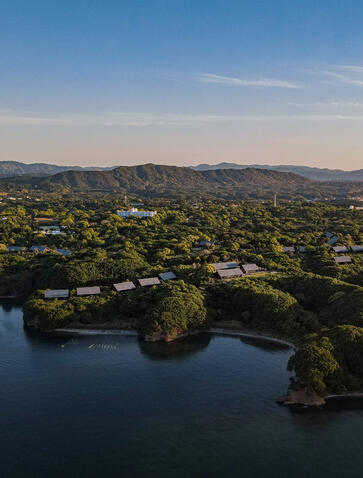 Aerial view of Amanemu resort nestled among forested hills and tranquil waterways in Japan.
