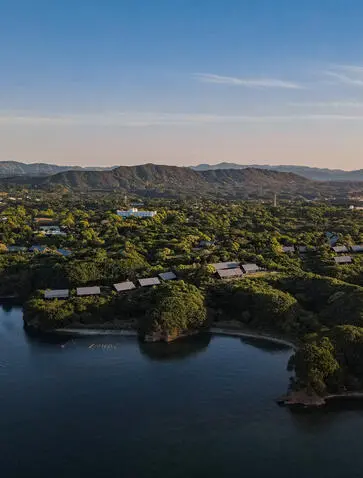 Aerial view of Amanemu resort nestled among forested hills and tranquil waterways in Japan.