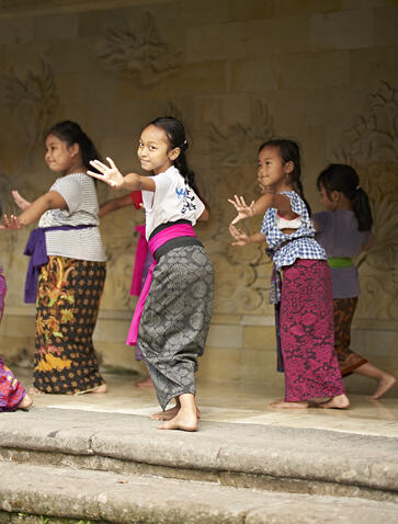Four young dancers in colourful sarongs learning traditional Balinese dance at Amandari.
