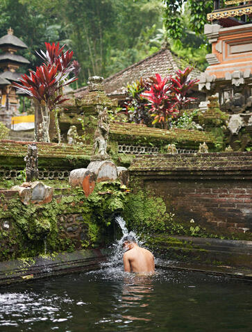 Guest participating in Melukat water blessing ceremony at Amandari, Indonesia.
