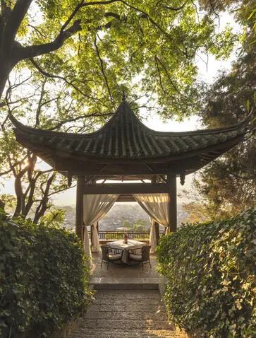 大研安缦度假村的餐饮馆，传统中式亭阁建筑，绿树成荫。