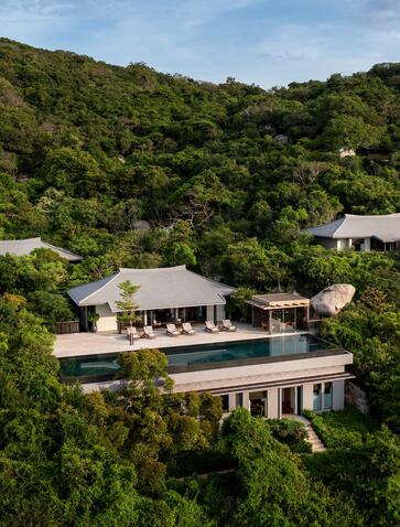 Aerial view of a residence at Amanoi nestled among forested hillside in Vietnam.