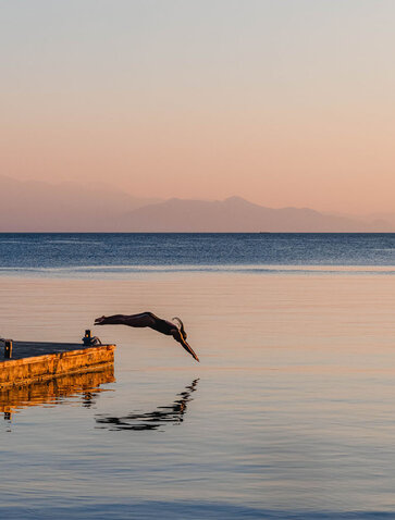 Outrigger canoe at sunrise in still waters off Amanwana, Sumbawa, Indonesia.