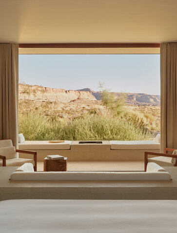 Desert suite bedroom at Amangiri with panoramic window framing canyon landscape.